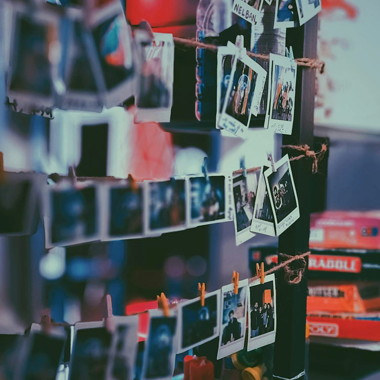 Printed photos displayed on a white shelf
