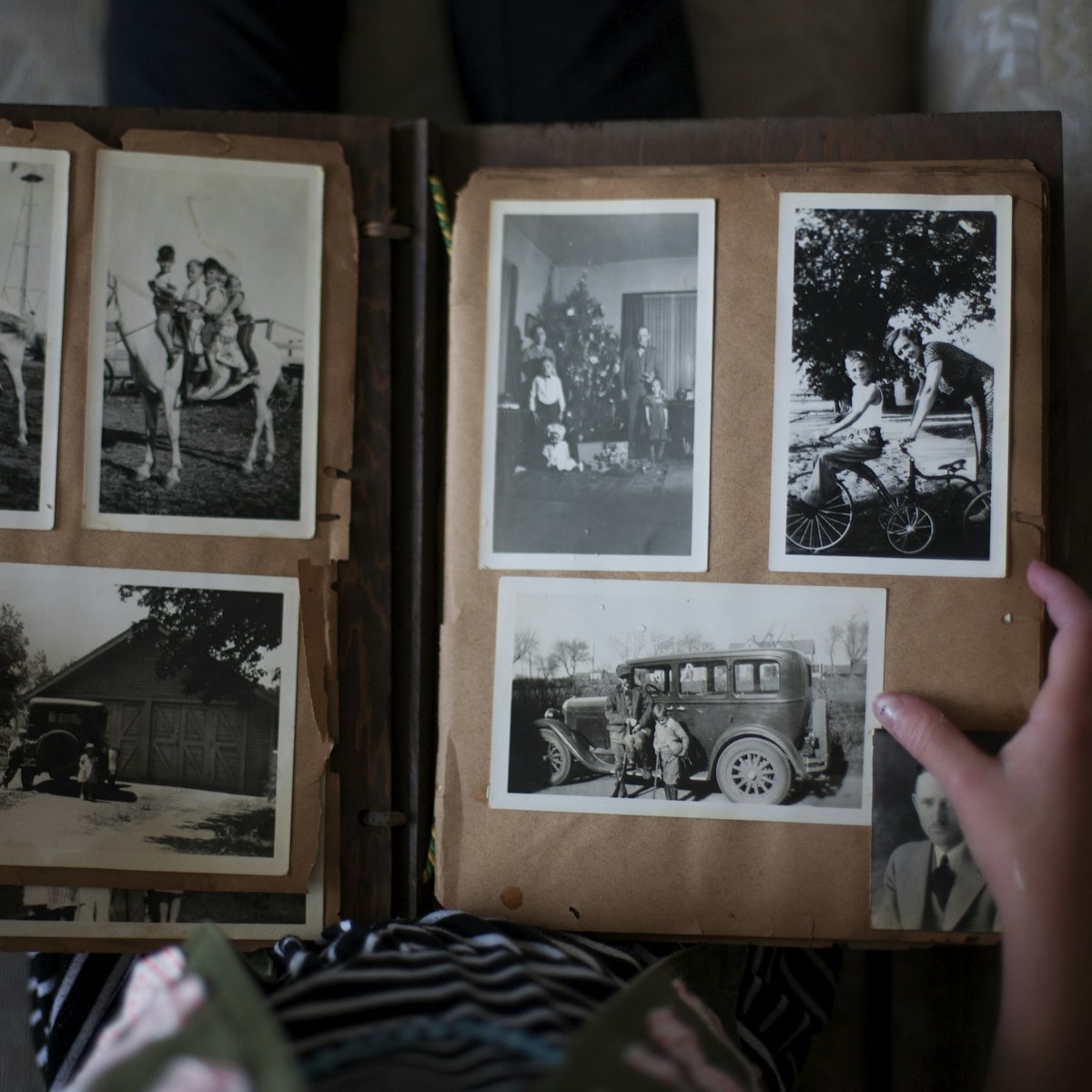 Hands opening a photo album with printed photos