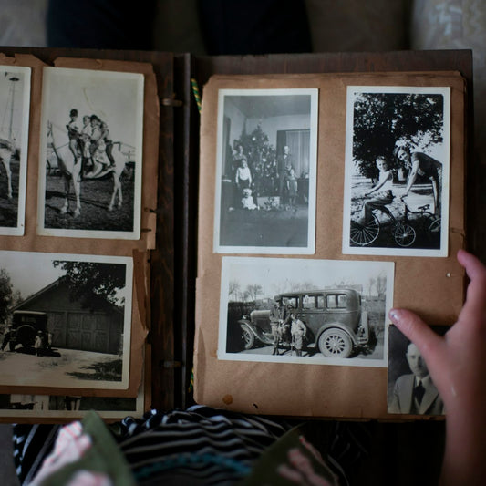 Hands opening a photo album with printed photos